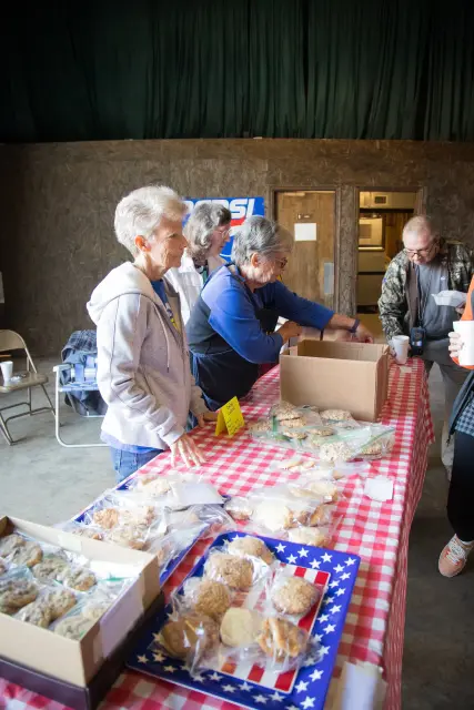 Volunteers set out desserts on a checked tablecloth